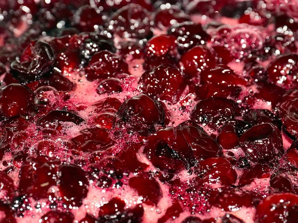 Ateş üstünde pişerken kiraz reçeli yüzeyinde köpük kaynıyor.