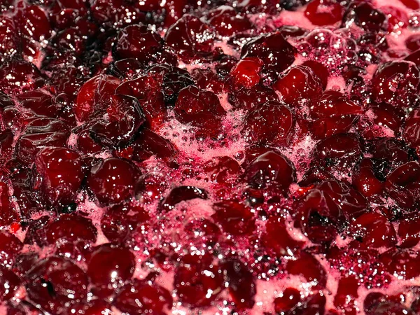 Ateş üstünde pişerken kiraz reçeli yüzeyinde köpük kaynıyor.