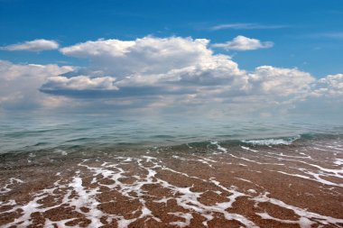 Güzel kumlu sahil ve bulutlu yaz gökyüzü