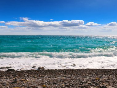 Güzel deniz plajı ve ufukta güneşli gökyüzü.