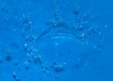 Bir damla temiz su tarafından vurulduktan sonra sıvının yüzeyindeki zarif desenler.