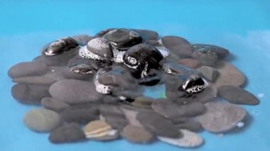 şeffaf saf su damlası taş yığınına düşer.
