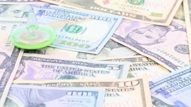 Bir plastik fırıldak, ticaret sisteminin dengesi için bir sembol olarak Amerikan doları banknotları yığını üzerinde döner
