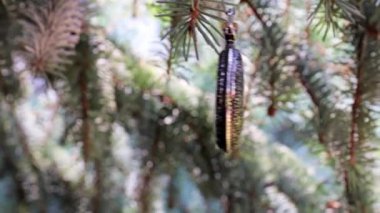 Yılbaşı ağacı dalında asılı antika bir cep saati.