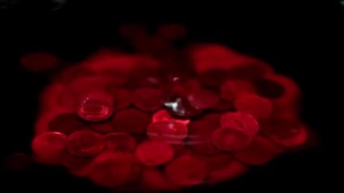 Kanlı bir damla, içinde Rus rublesi olan bir metal madeni paranın bulunduğu bir sıvının yüzeyine düşer.