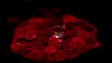 Kanlı bir damla, içinde Rus rublesi olan bir metal madeni paranın bulunduğu bir sıvının yüzeyine düşer.