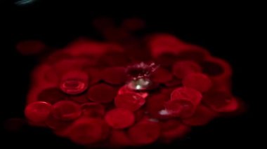 Kanlı bir damla, içinde Rus rublesi olan bir metal madeni paranın bulunduğu bir sıvının yüzeyine düşer.