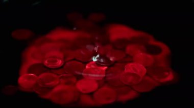 Kanlı bir damla, içinde Rus rublesi olan bir metal madeni paranın bulunduğu bir sıvının yüzeyine düşer.