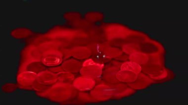 Kanlı bir damla, içinde Rus rublesi olan bir metal madeni paranın bulunduğu bir sıvının yüzeyine düşer.