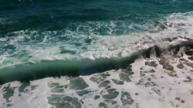 Güçlü deniz dalgaları ve temiz sahil taşları