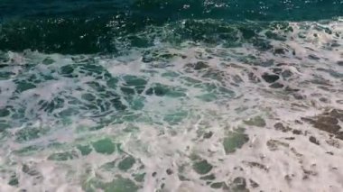 Güçlü deniz dalgaları ve temiz sahil taşları