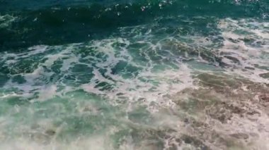 Güçlü deniz dalgaları ve temiz sahil taşları