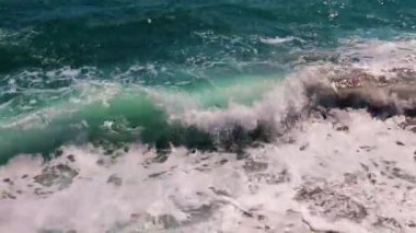 Güçlü deniz dalgaları ve temiz sahil taşları