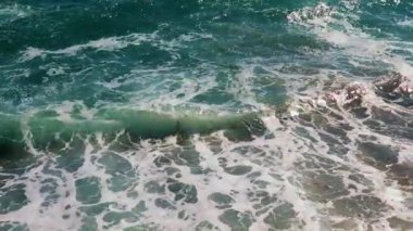 Güçlü deniz dalgaları ve temiz sahil taşları