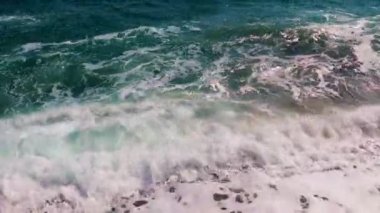 Güçlü deniz dalgaları ve temiz sahil taşları