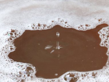 Sıvının yüzeyine bir damla kirli su düşer.