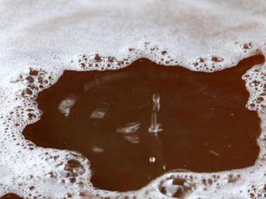 Sıvının yüzeyine bir damla kirli su düşer.