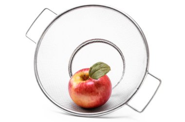 Beyaz bir arka planda kevgirde olgun kırmızı elmalar