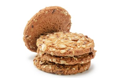 Beyaz arka planda yumuşak gölgeli tahıl taneleri serpiştirilmiş yulaf ezmeli kurabiyeler.