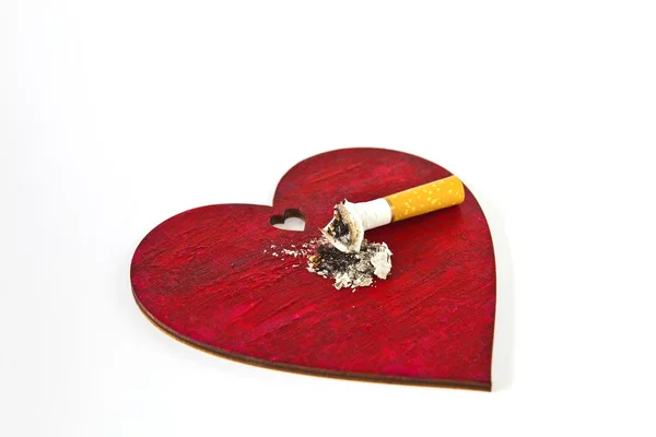 Corazón rojo y colilla de cigarrillo — Foto de Stock