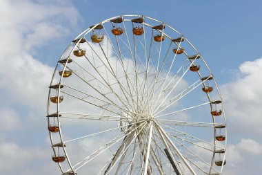 Dönme dolabın kısmi görüntüsü, arka planda mavi gökyüzü.