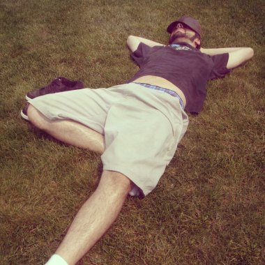 Genç adam çimenlerde uzanmanız