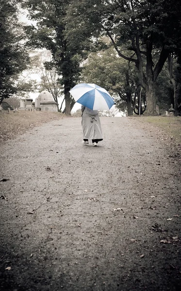 在多雨的墓地里走的人 — 图库照片