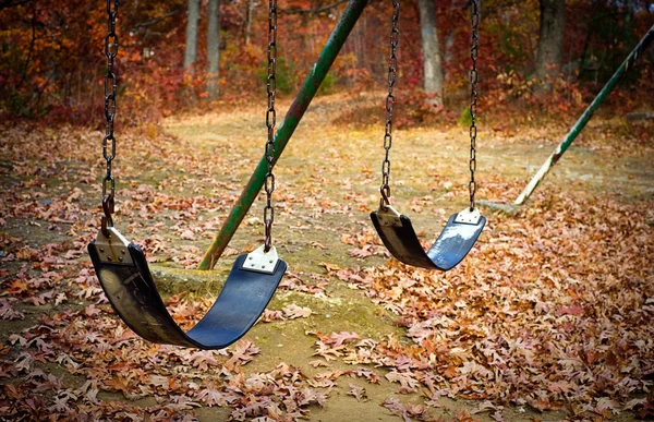 Velho swingset em um parque no outono — Fotografia de Stock