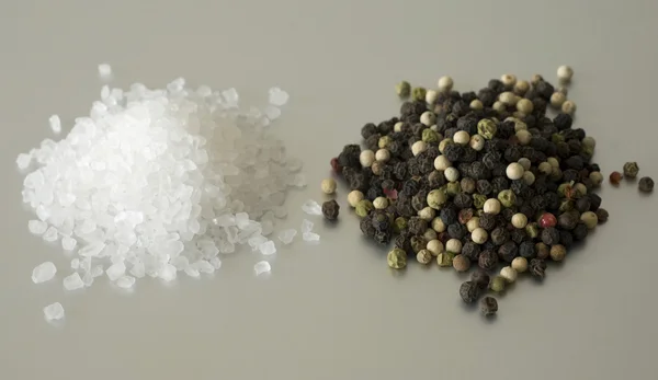 Pile di sale marino e grani di pepe assortiti — Foto Stock