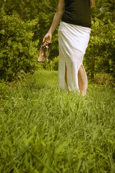 Woman in a vineyard holding sandals — Stock Photo, Image