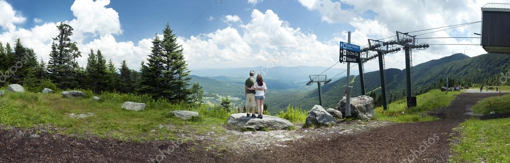 Couple look out over panoramic view from Mount Mansfield