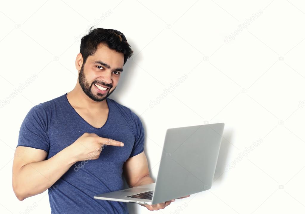 A handsome young Indian man working on laptop