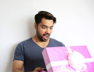 Beyaz b izole sürpriz hediye kutusu tutan genç bir Hintli adam