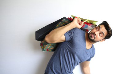 Alışveriş torbaları beyaz arka plan üzerinde tutan bir Hint delikanlı.