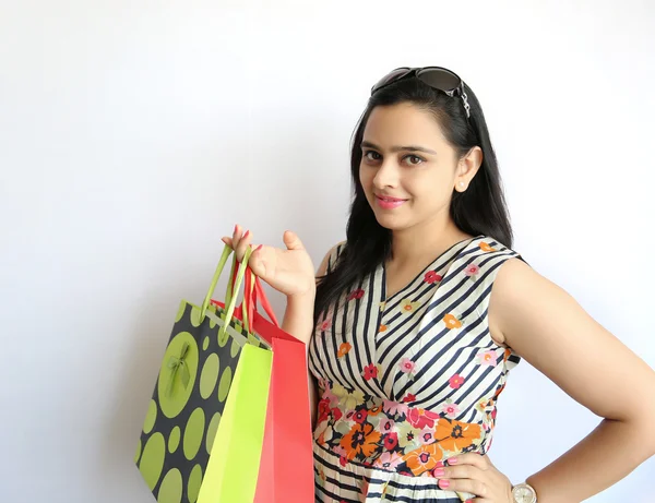 Beauty Indian Woman holding shopping bags on white background.