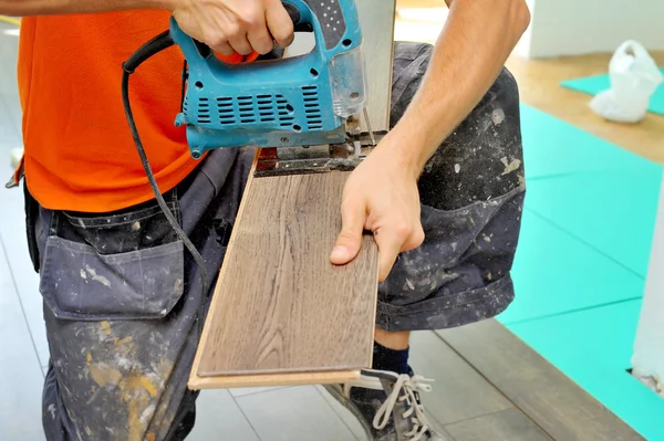 Carpinteiro fazendo piso laminado — Fotografia de Stock