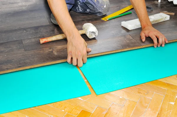 Carpinteiro fazendo piso laminado — Fotografia de Stock