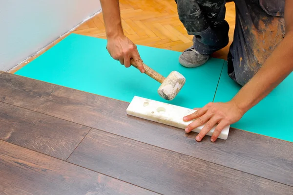 Carpinteiro fazendo piso laminado — Fotografia de Stock