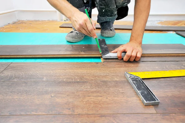 Carpinteiro fazendo piso laminado — Fotografia de Stock