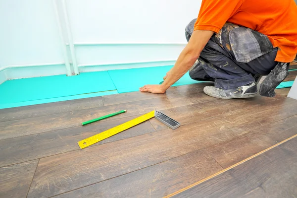 Carpintero haciendo trabajo de piso laminado —  Fotos de Stock