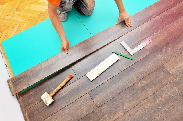 Carpinteiro fazendo piso laminado — Fotografia de Stock