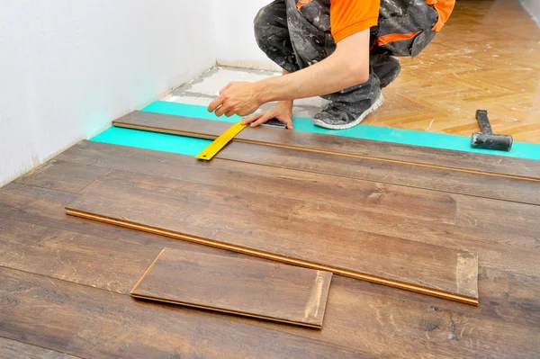 Carpinteiro fazendo piso laminado — Fotografia de Stock