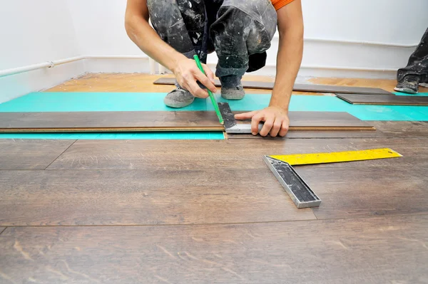 Carpinteiro fazendo piso laminado — Fotografia de Stock