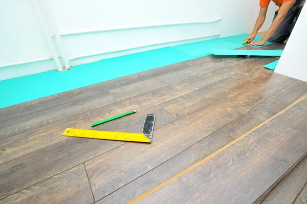 Carpinteiro fazendo piso laminado — Fotografia de Stock