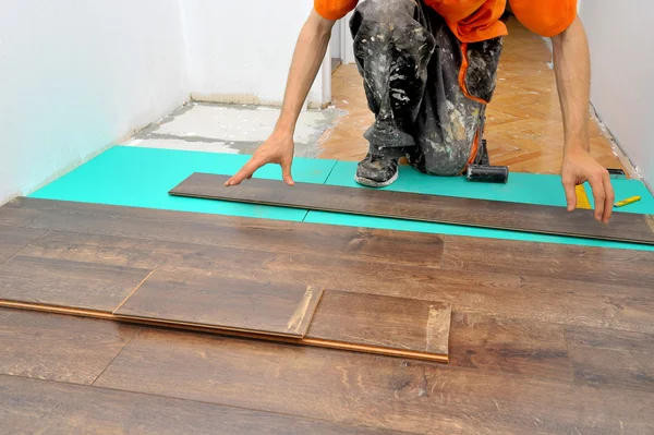 Carpintero haciendo trabajo de piso laminado — Foto de Stock