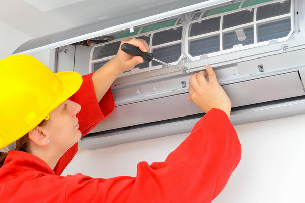 Woman worker adjusting air conditioner system