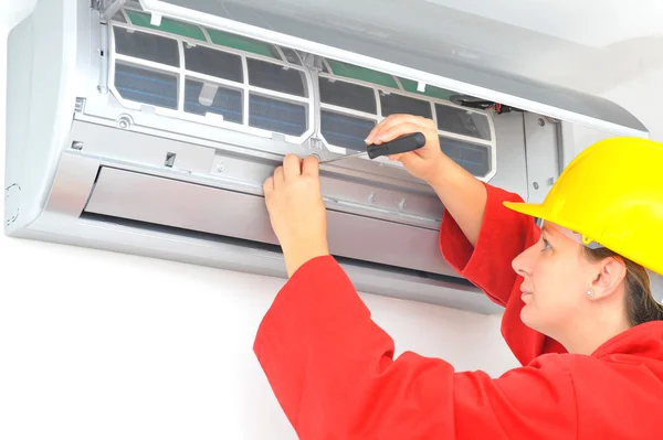 Vrouw werknemer airconditioner systeem aanpassen — Stockfoto