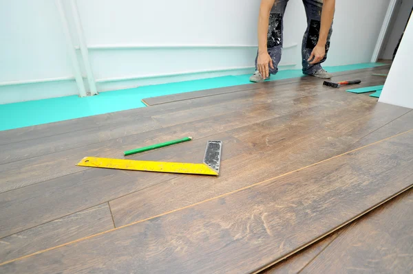 Carpintero haciendo trabajo de piso laminado —  Fotos de Stock