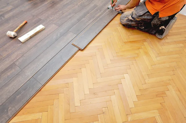 Stolarz robi pracy podłogi laminowanej — Zdjęcie stockowe
