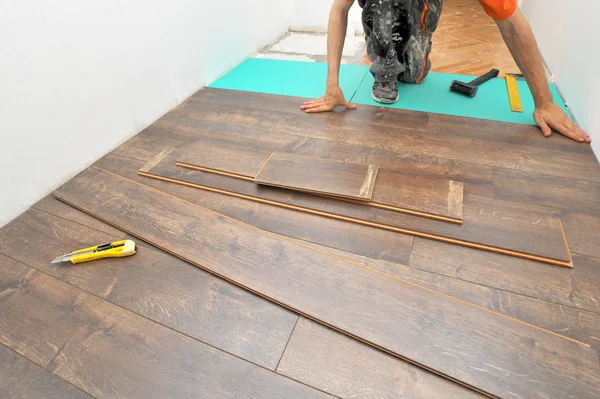 Carpinteiro fazendo piso laminado — Fotografia de Stock
